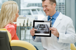 Dentist showing his patient an xray image from adstra imaging on an iPad