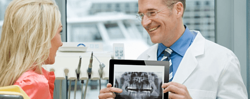 dentist using adstra dental software on tablet